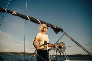 A woman finding meaning in retirement steering a sailboat
