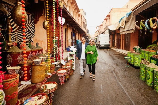 a couple stroll a market street on their trip of a lifetime||