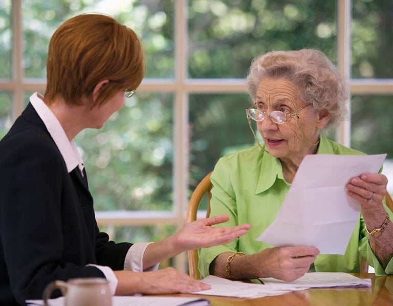 a woman discussing credit and reverse mortgages|A senior woman inquiring about credit ratings and reverse mortgages